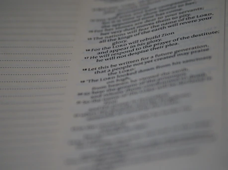 A close-up of a page from a book, featuring text in a serif font. The text appears to be of a religious or poetic nature, with some lines highlighted in bold.