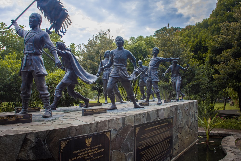 a group of statues of men holding swords