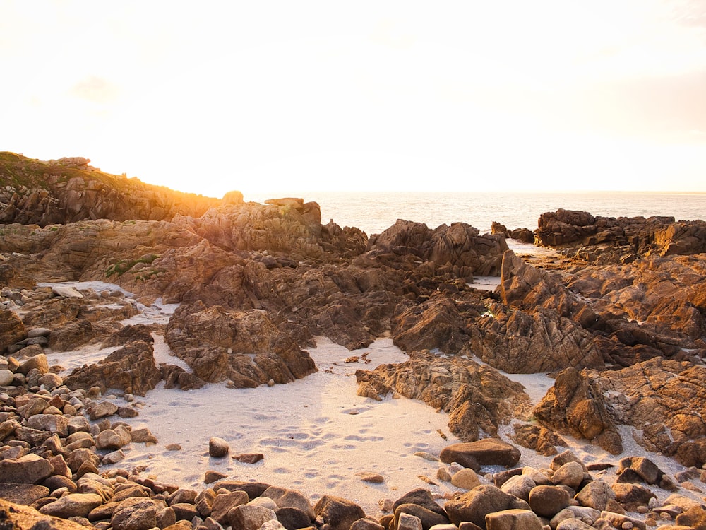 a rocky beach with water in the background