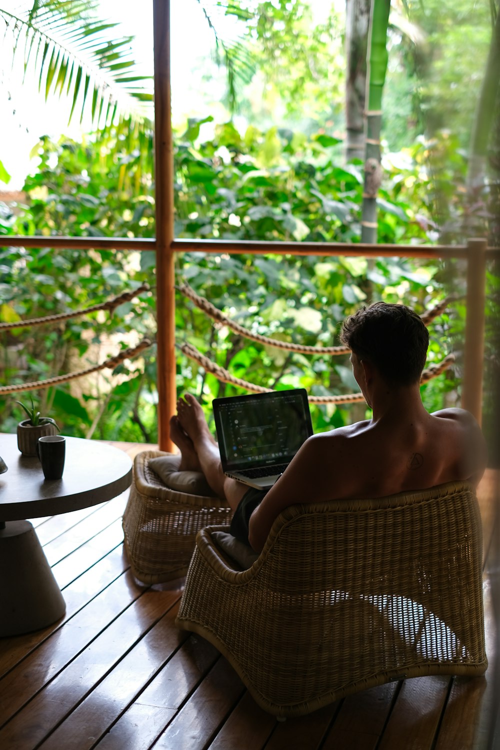 a person sitting on a chair using a laptop