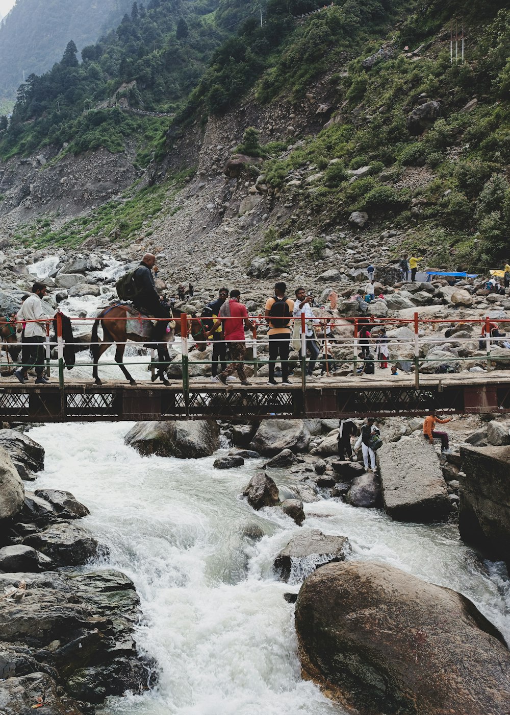 a group of people on a bridge over a river