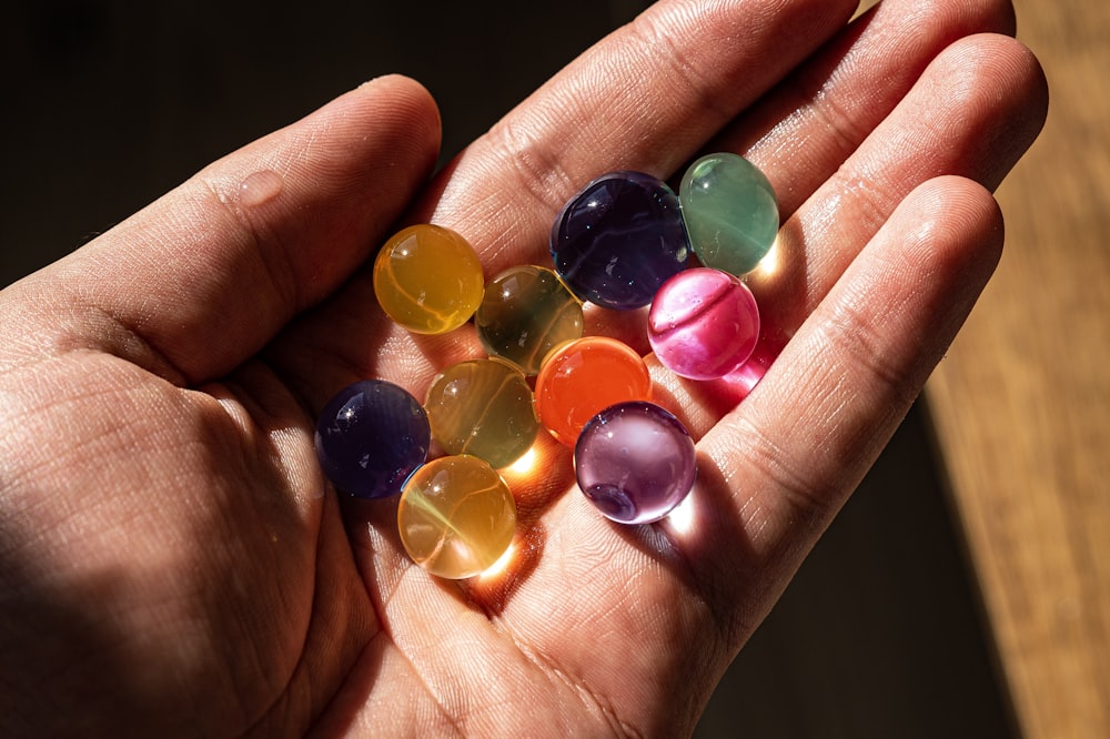 a hand holding a group of colorful round candies
