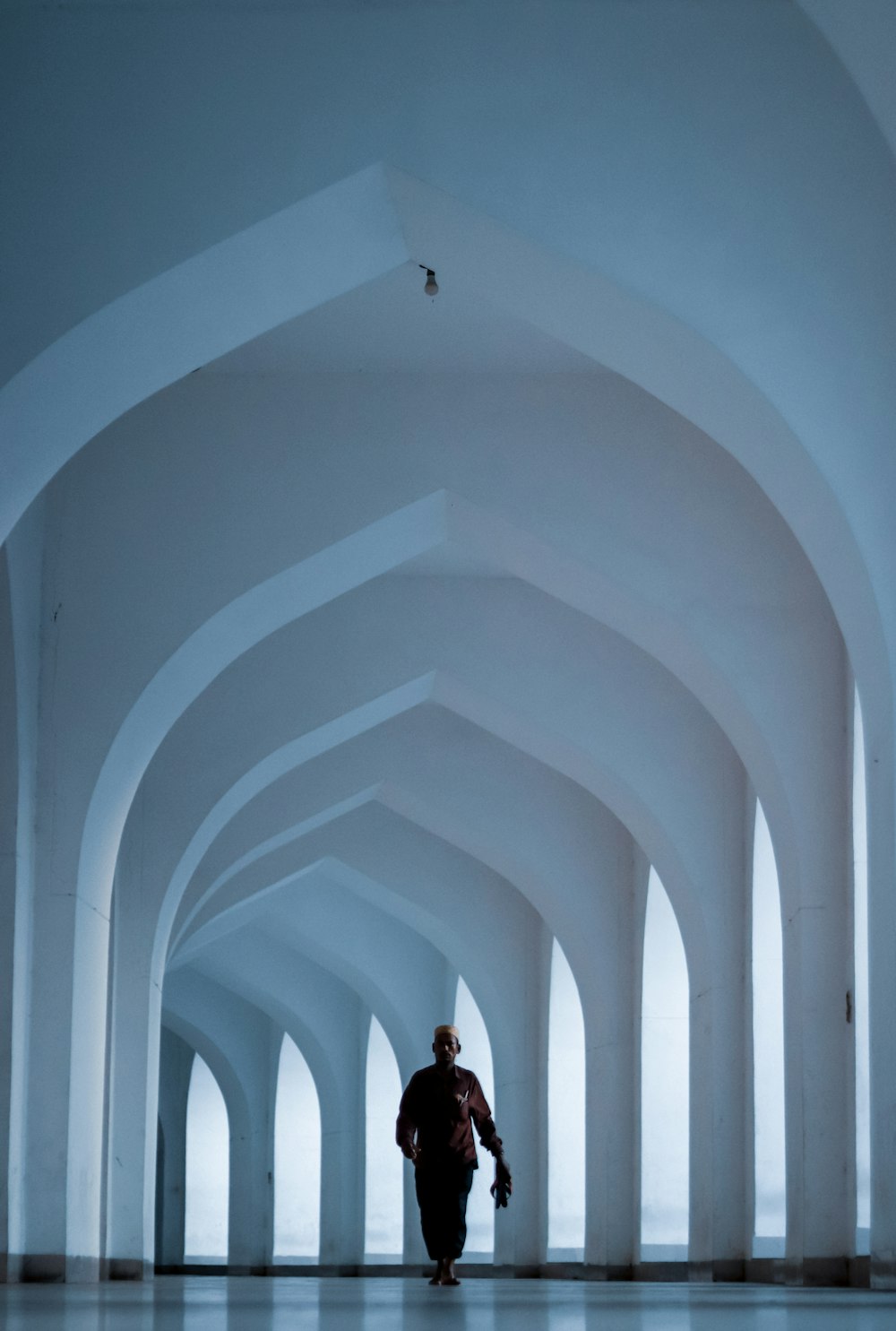 a man walking in a large white building