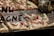 Slices of pizza topped with mozzarella cheese, cherry tomatoes, and basil leaves are displayed on a metal tray. The word 'TENTAZIONE' is partially visible on a glass surface positioned in front of the pizza. There's also a price tag placed on the tray, indicating the cost of 5.90 Euros.