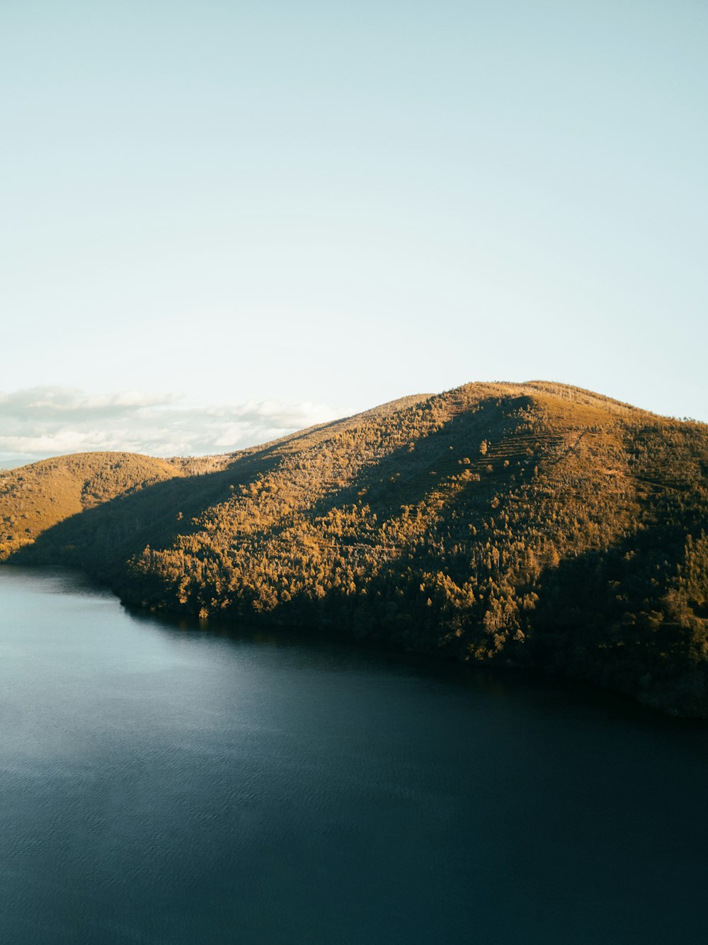 a body of water with hills in the back