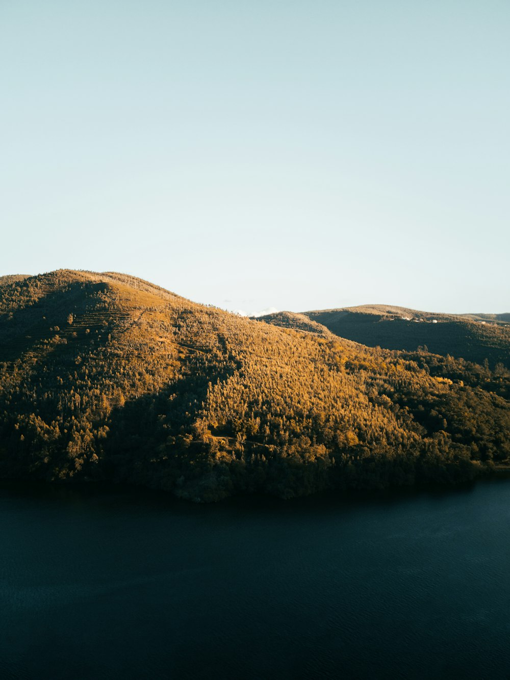 a body of water with hills in the back