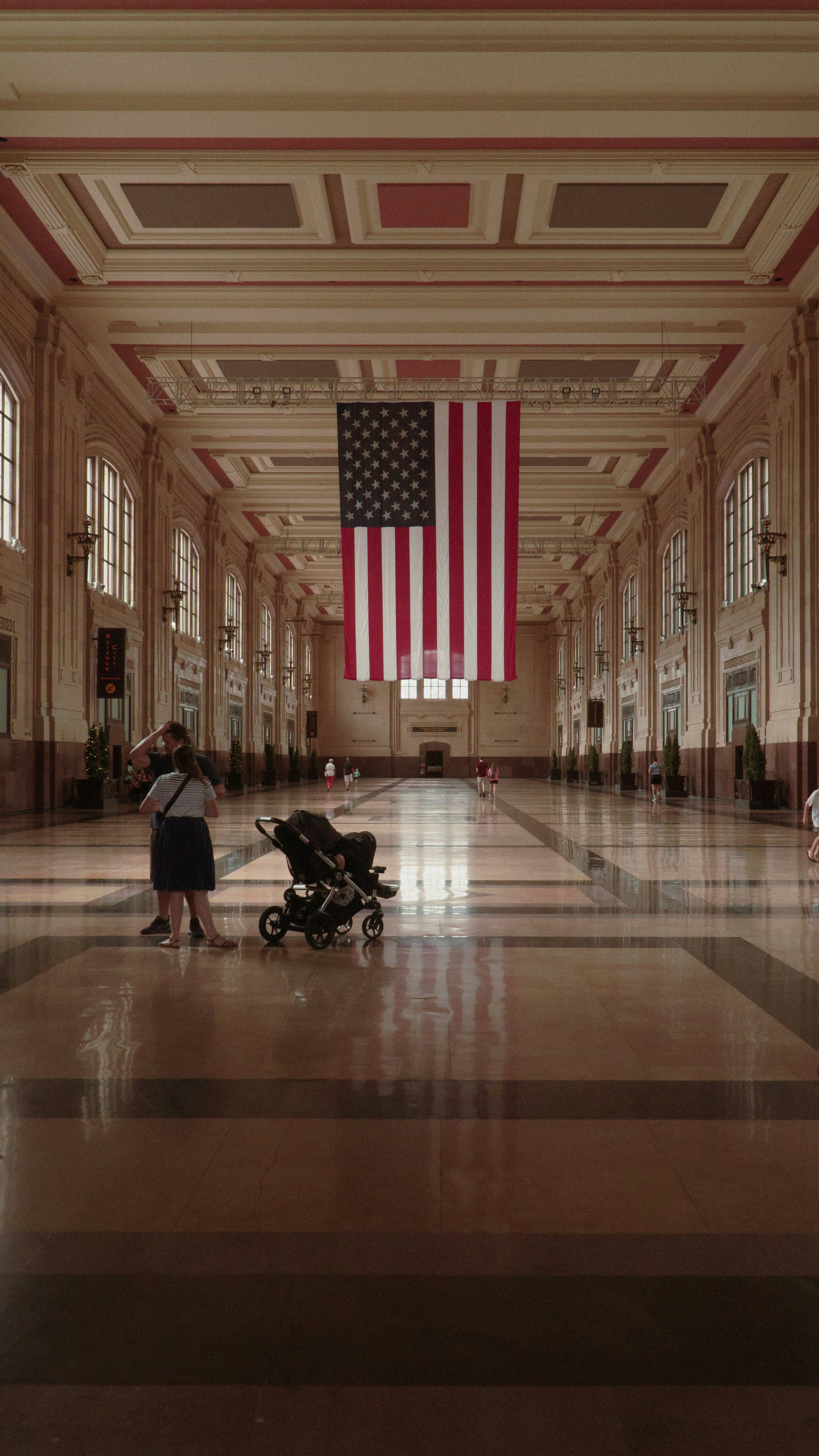 a person standing in a large building with a flag on a pole