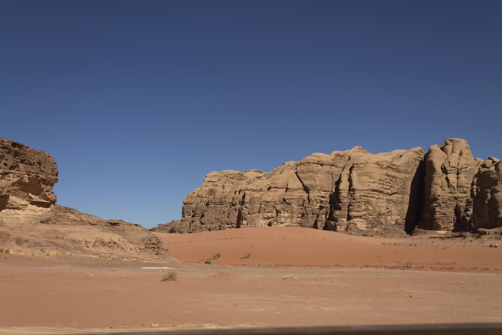 a desert landscape with a rock formation with Wadi Rum in the background