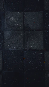 Interactive square tiles with rounded corners glowing softly in black and ochre tones on a dark background.
