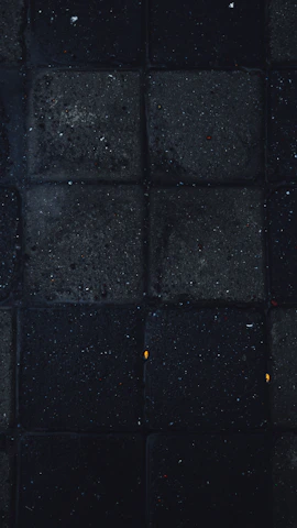 Interactive square tiles with rounded corners glowing softly in black and ochre tones on a dark background.