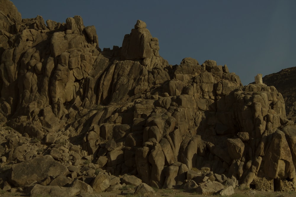 a rocky mountain with a blue sky