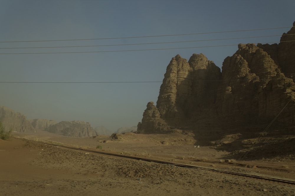 a desert landscape with a road and mountains in the background