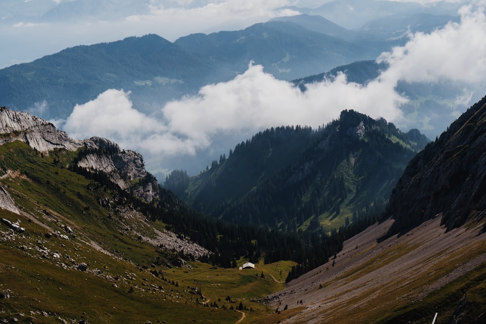 a valley between mountains with clouds