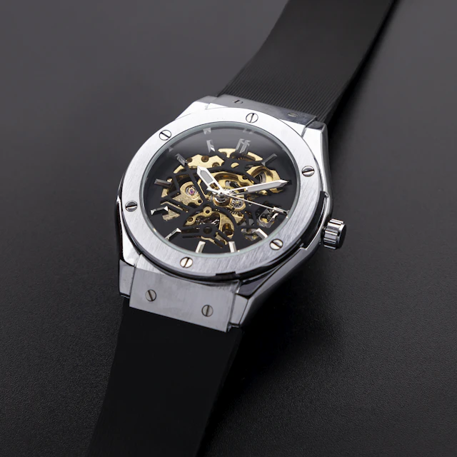 A wristwatch worn on a wrist, photographed against a black background