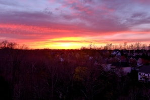 A colorful sunset casting warm hues over a suburban neighborhood.