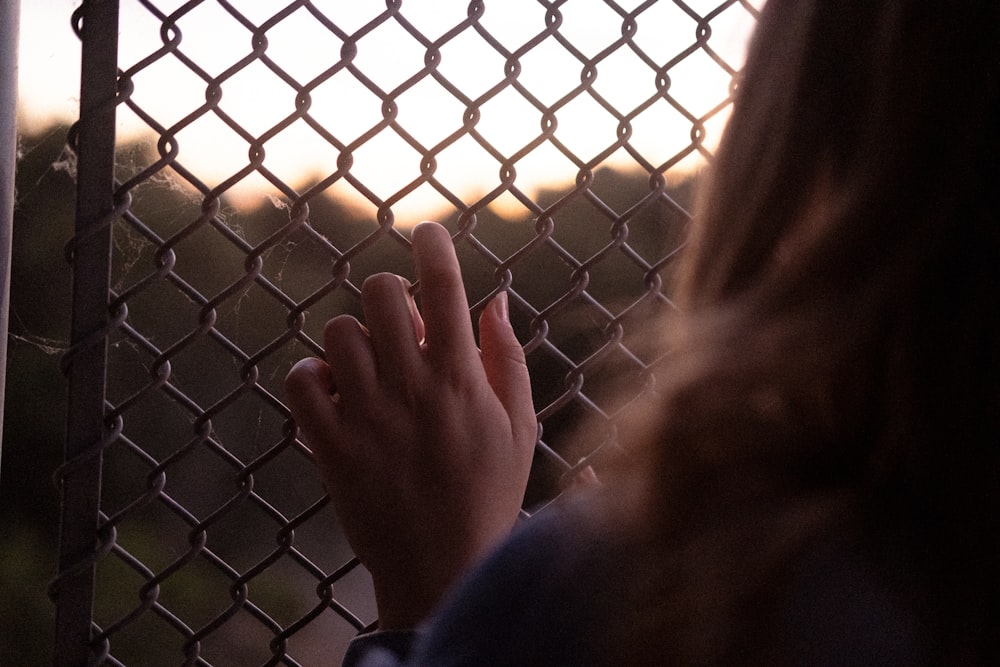 a person's hand on a fence