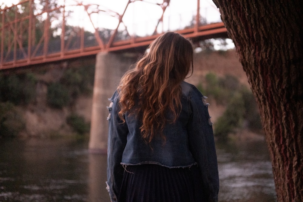 a woman standing in front of a bridge