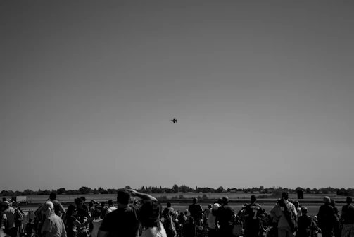 Crowd watching the night airshow with illuminated jets.