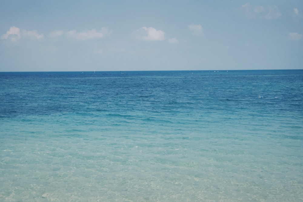 a body of water with blue sky and clouds