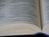 An open book with visible text emphasizing spiritual and moral themes. The focus is on multiple lines of text, likely from a religious or philosophical document.