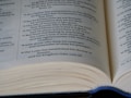 An open book with visible text emphasizing spiritual and moral themes. The focus is on multiple lines of text, likely from a religious or philosophical document.