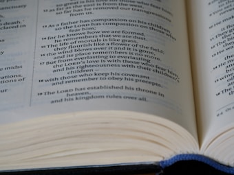 An open book with visible text emphasizing spiritual and moral themes. The focus is on multiple lines of text, likely from a religious or philosophical document.
