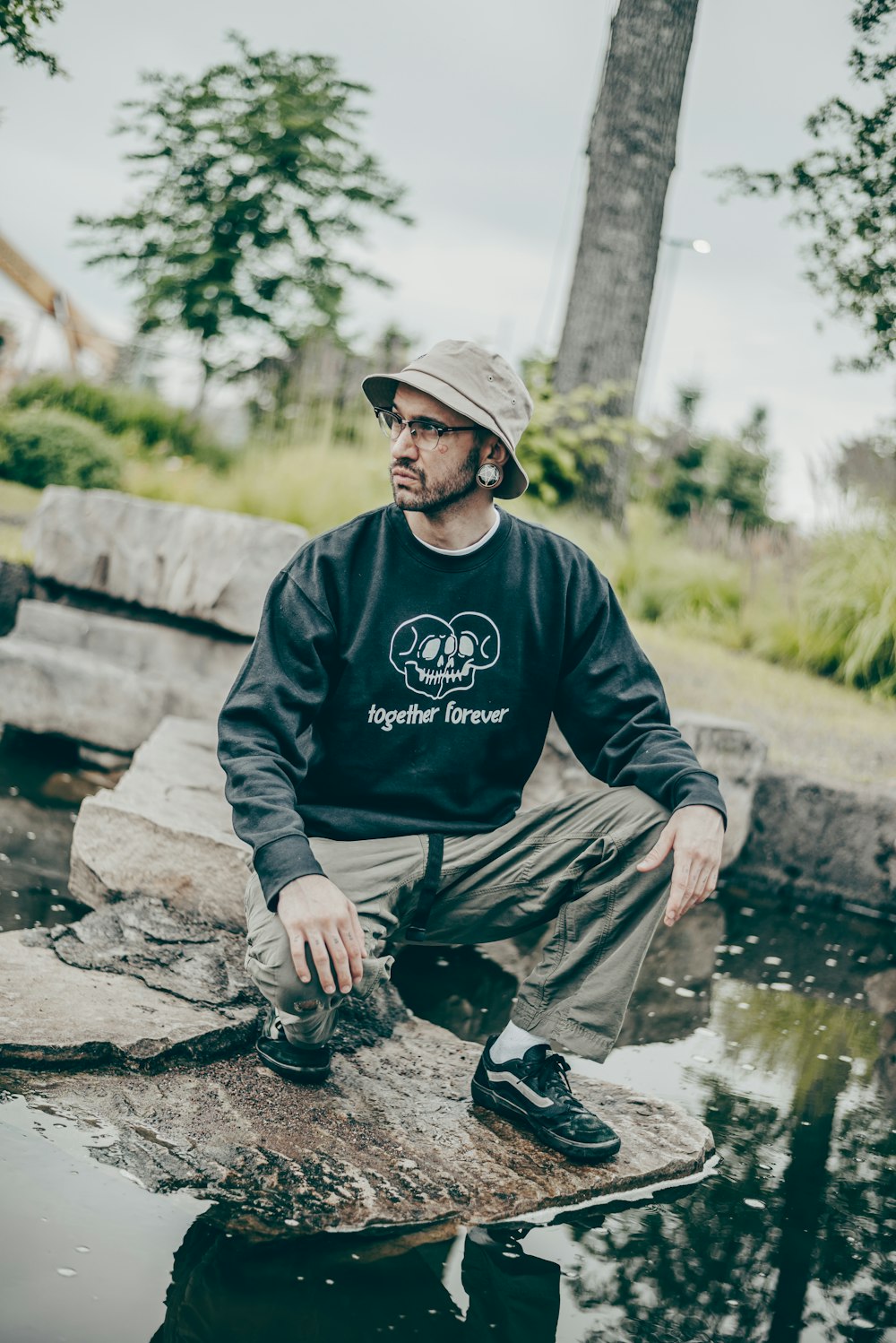 a man sitting on a rock in a pond