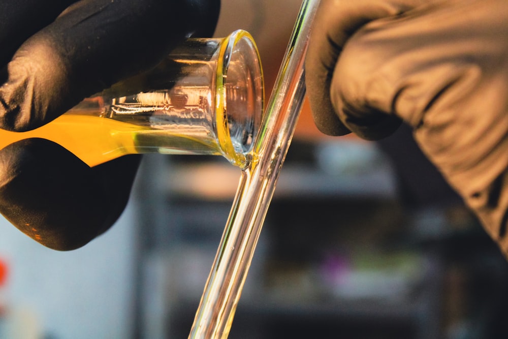 close-up of a person pouring liquid into a glass