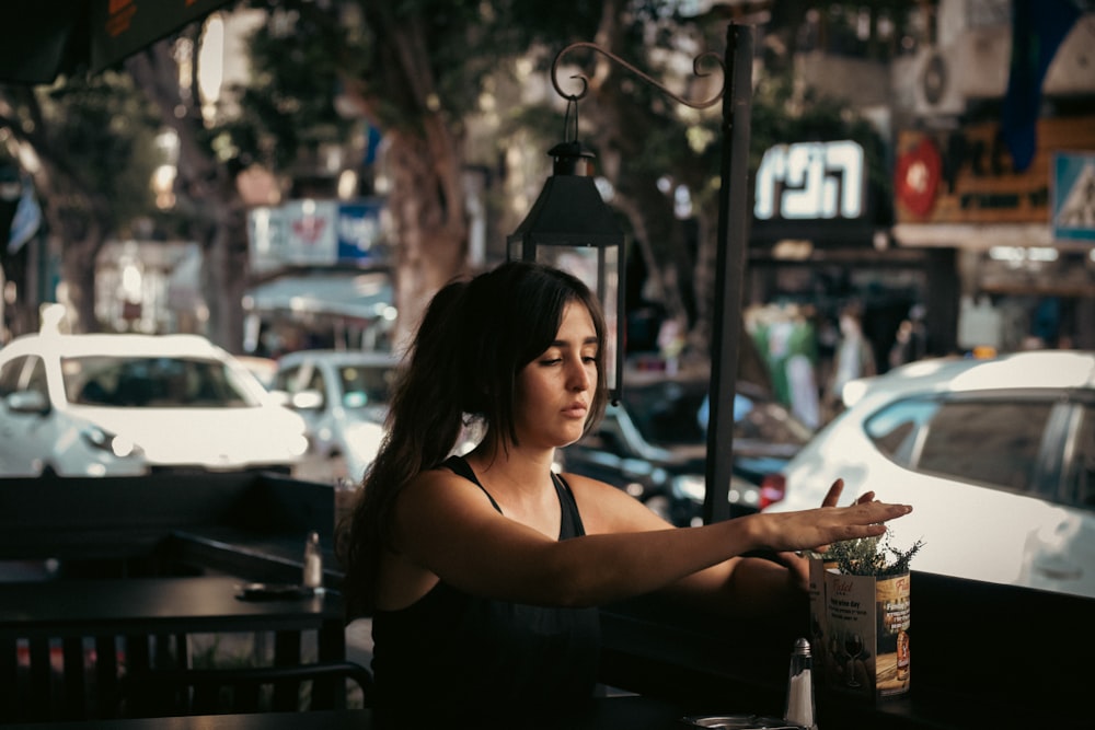 a woman sitting on a sidewalk