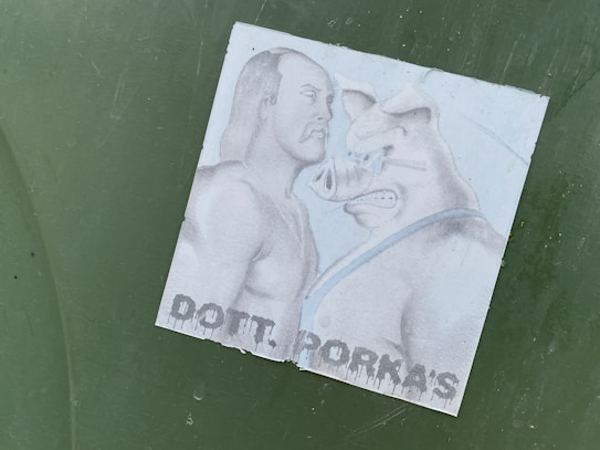 A detailed drawing featuring a muscular man facing off against an anthropomorphic pig wearing a strap. The background is simple and the text 'DOTT. PORKA'S' is visible at the bottom, with a graffiti-like style.