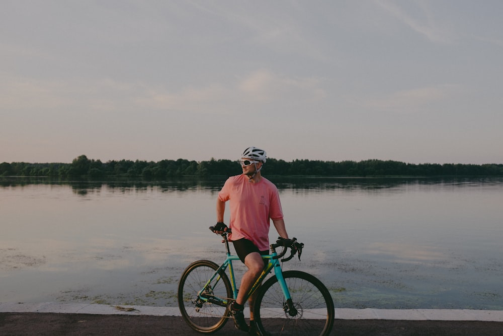 a man on a bicycle by a body of water