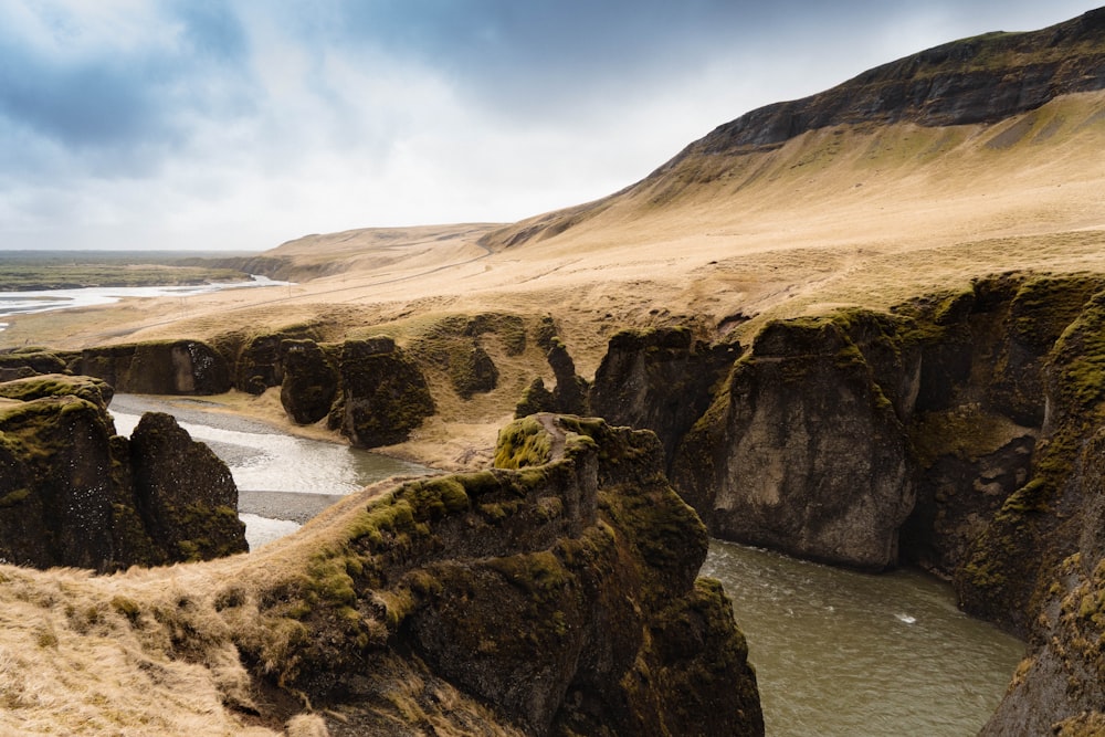 a rocky beach with a body of water in the background