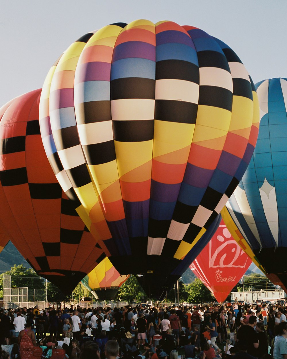 a group of people standing in front of a large colorful hot air balloon