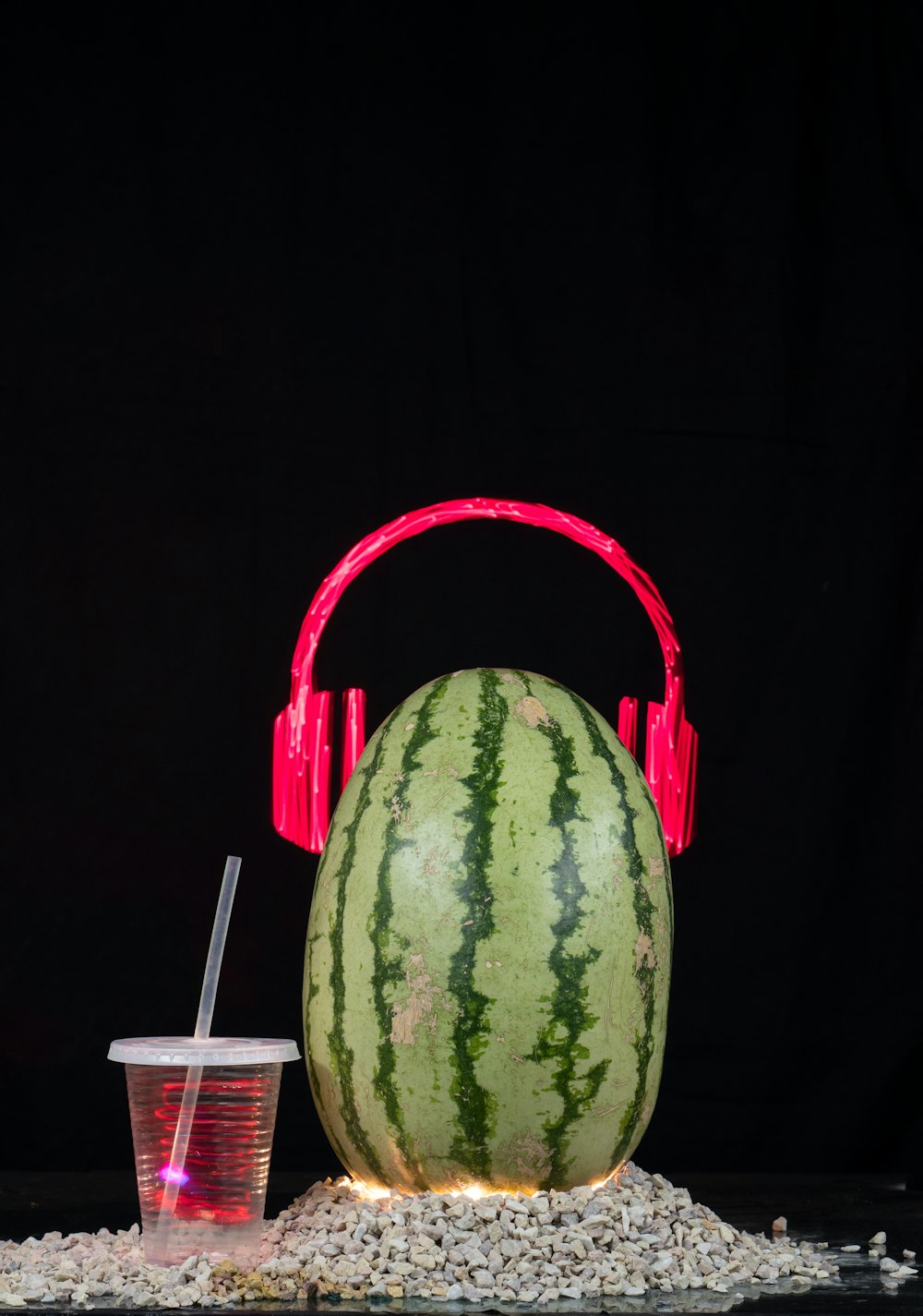 a watermelon and a cup of drink on a table