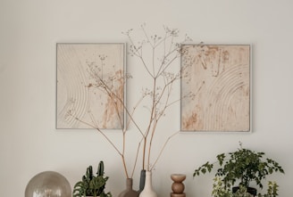 A calming arrangement of nature-inspired wall art in soft gold tones.