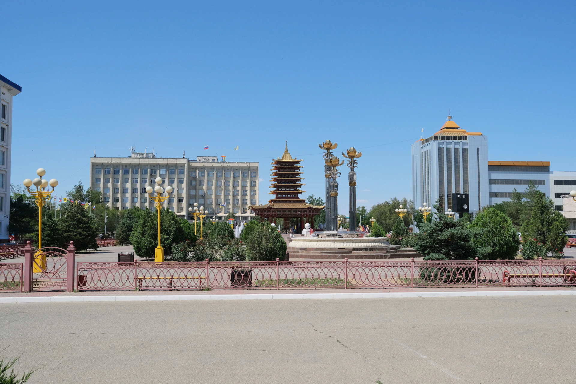 a large building with a gold domed roof and a red fence in front