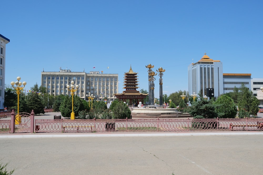 a large building with a gold domed roof and a red fence in front