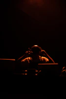 Silhouetted profile of a woman lost in listening, bathed in warm, low light.