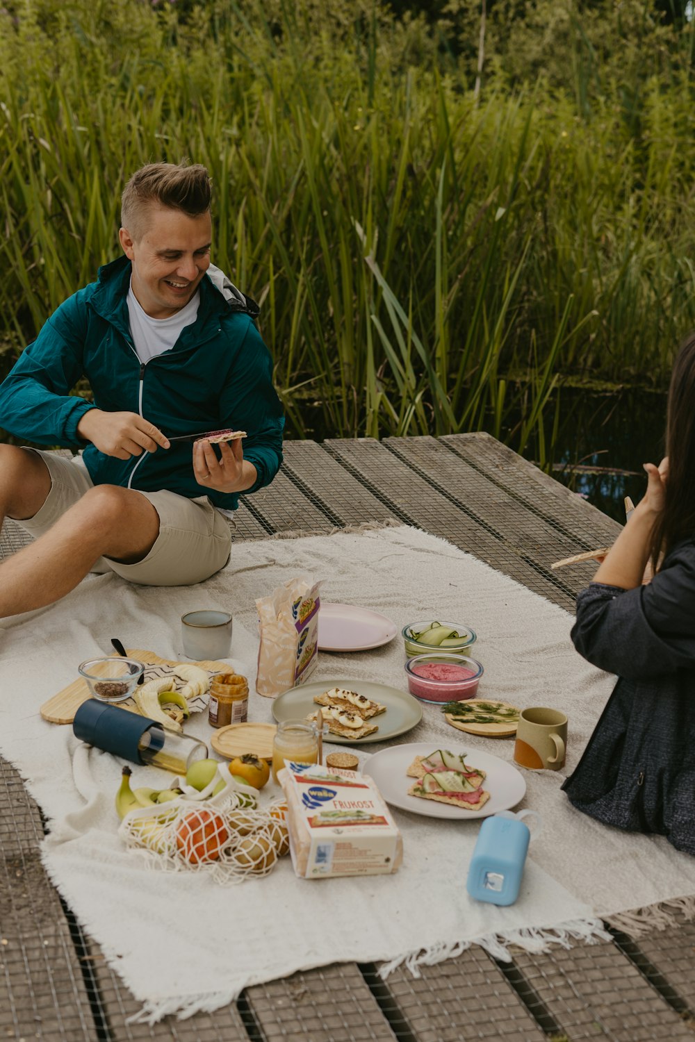 a man and woman sitting at a table with food on it