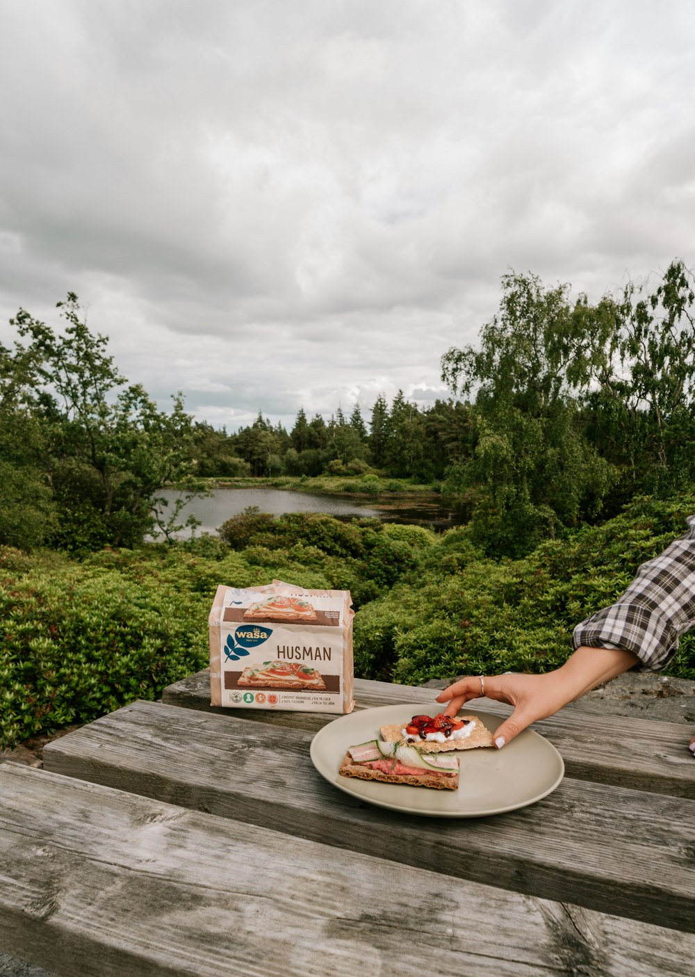 a person sitting on a dock with food and a box of food