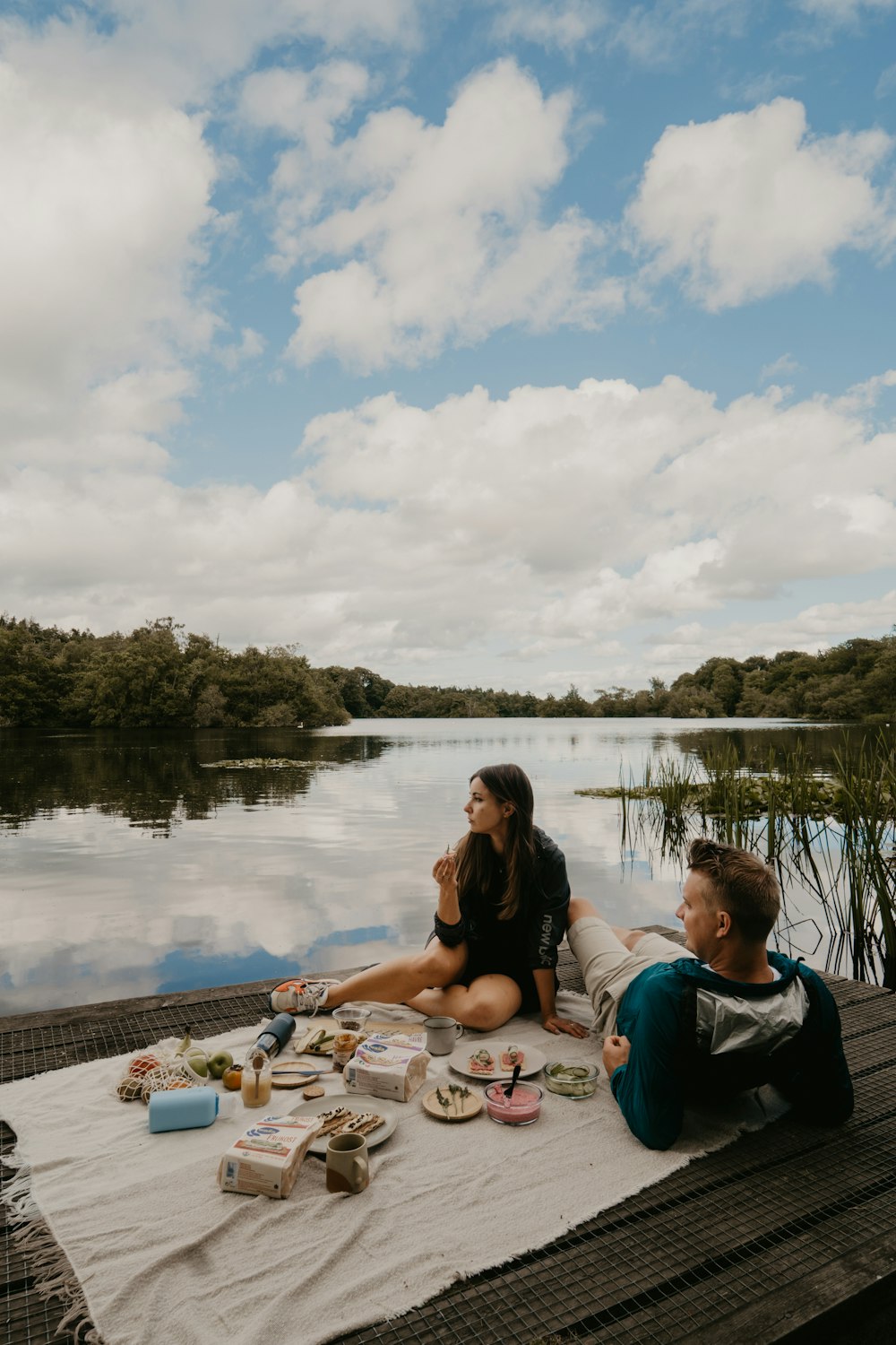 a group of people sitting on a table by a body of water