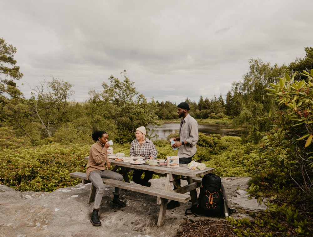 a group of people sitting at a table outside