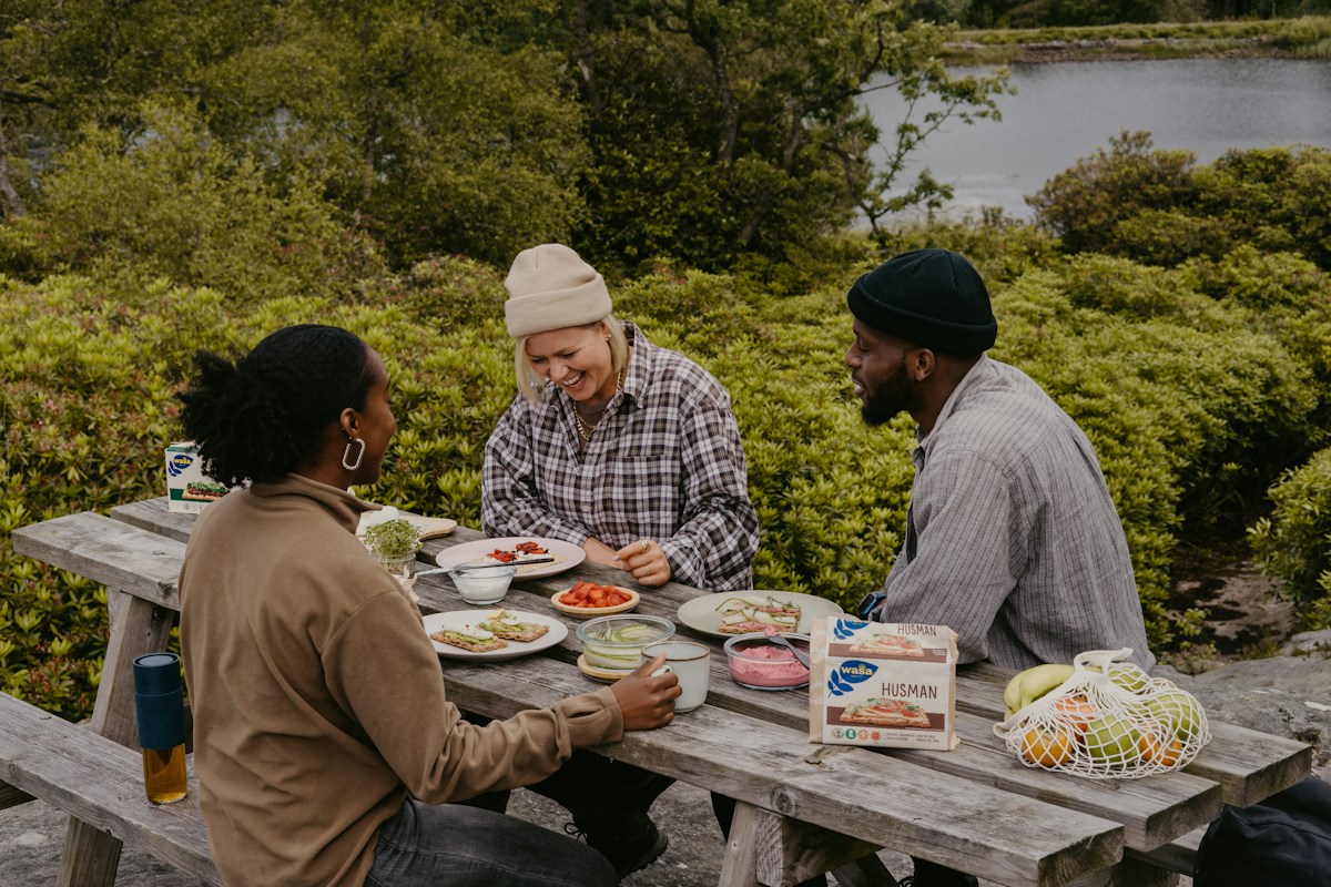 A group of young people enjoying a meal at a picnic table during a youth retreat.