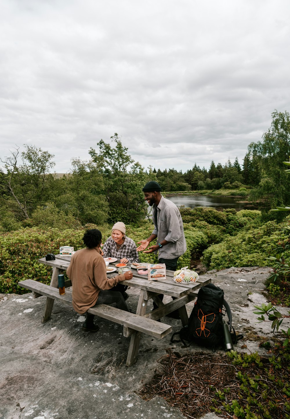 Un grupo de personas sentadas en una mesa de picnic en un bosque