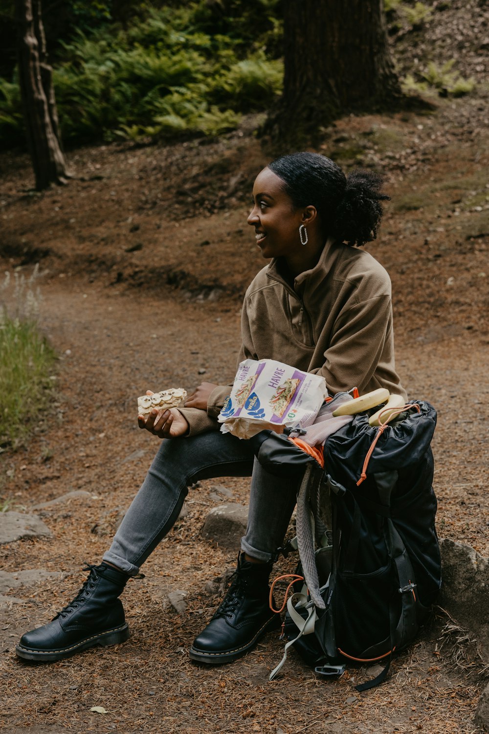 a person sitting on a rock reading a book