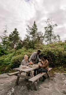 a group of people sitting at a picnic table