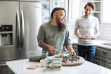 Two support workers sharing a light moment while preparing a meal together.