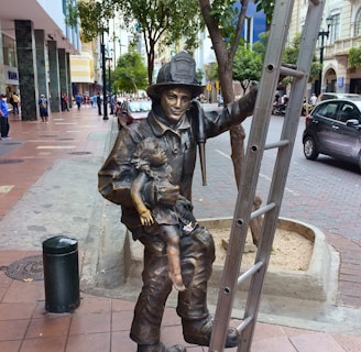 a statue of a man holding a sword on a sidewalk