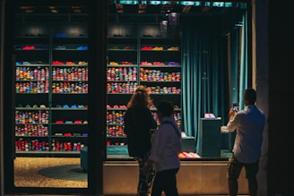 people standing in front of a display of bottles