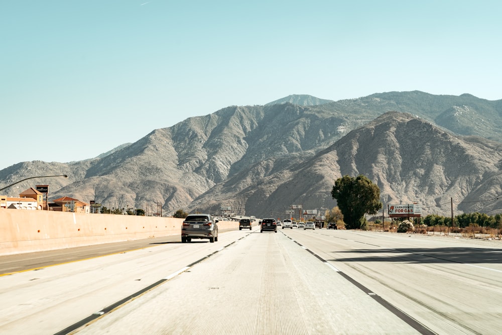 a highway with cars on it and mountains in the background